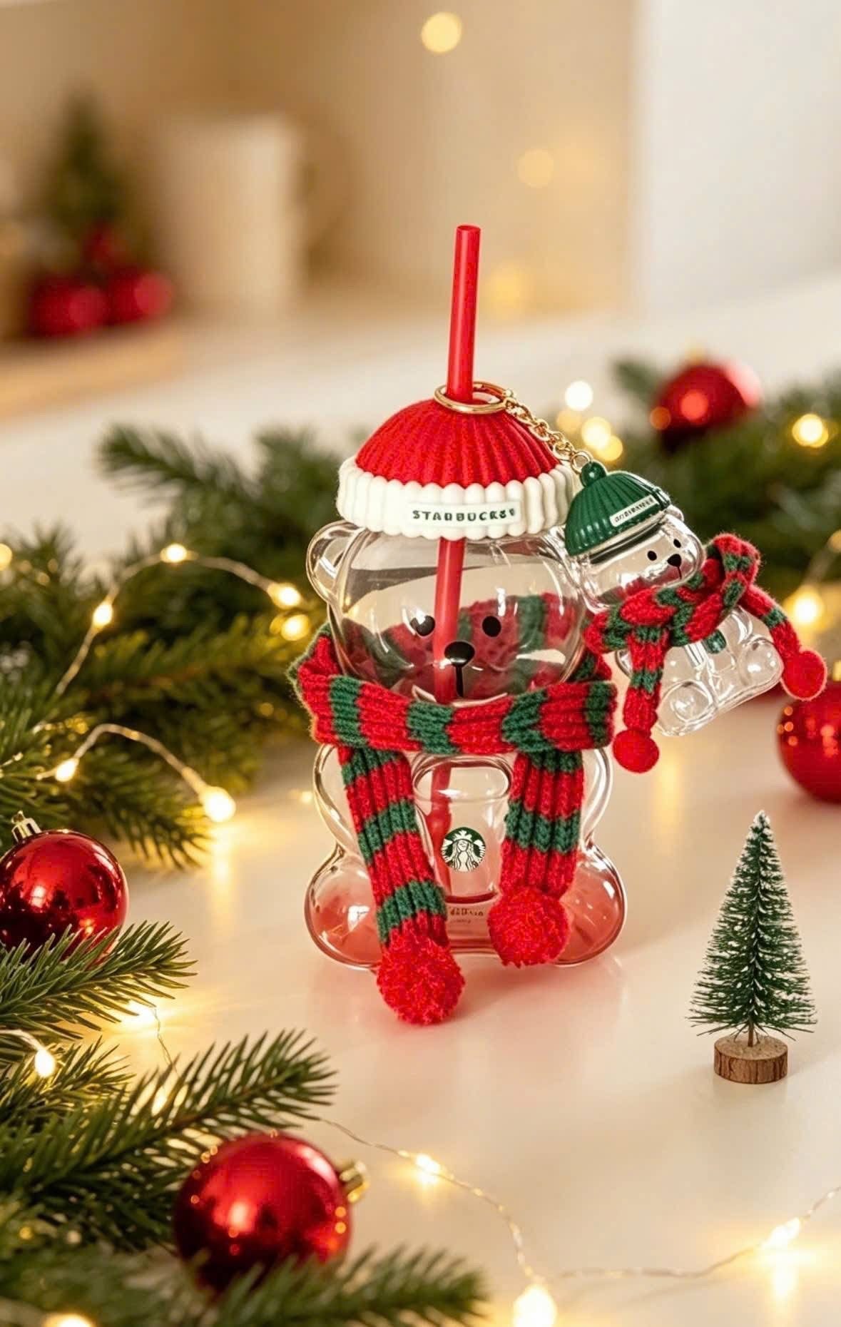 Vaso de vidrio Starbucks China Christmas 2026 con forma de osito, gorro rojo tejido, popote y bufanda navideña.